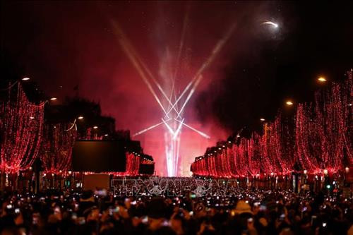 Đại lộ Champs-Elysees vẫn được trang hoàng rực rỡ và người dân Pháp đổ xuống đường phố Paris chờ đón màn pháo hoa thời khắc Giao thừa, bước sang Năm mới, ngày 1/1/2019. Ảnh: AFP/TTXVN