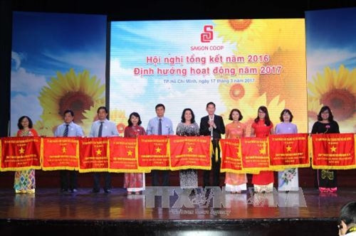 Phó Chủ tịch UBND TP. Hồ Chí Minh Trần Vĩnh Tuyến trao Cờ thi đua của UBND TP. Hồ Chí Minh cho các tập thể hoàn thành xuất sắc nhiệm vụ năm 2016. Ảnh: Thanh Vũ-TTXVN