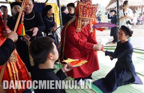 Thầy Then tiến hành phát bùa chú và buộc dây đỏ vào cổ tay mọi người để cầu tài, cầu lộc, xua đuổi tà khí… Ảnh: Hoàng Hải