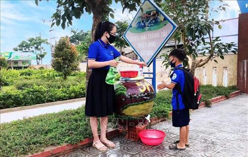 Giáo viên trường Tiểu học số 2 Quảng Văn (thị xã Ba Đồn, Quảng Bình) hướng dẫn học sinh cách rửa tay, sát khuẩn trước khi vào lớp. Ảnh: Võ Dung -TTXVN