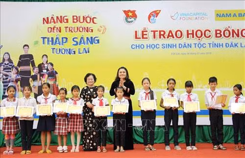 Bà Trương Mỹ Hoa, Nguyên Phó Chủ tịch nước, Chủ tịch Quỹ học bổng Vừ A Dính cùng lãnh đạo UBND tỉnh Đắk Lắk trao học bổng cho học sinh DTTS. Ảnh: Hoài Thu - TTXVN