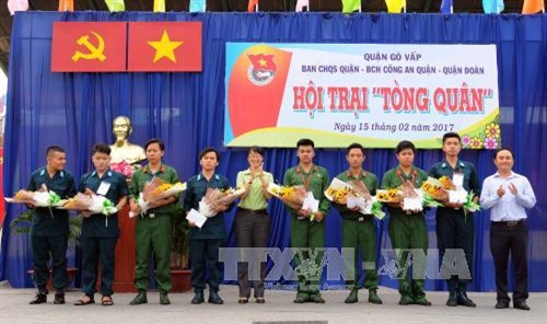 Đồng chí Trần Thị Diệu Thúy, Bí thư Quận ủy Quận Gò Vấp trao hoa và quà cho các tân chiến sĩ là đảng viên xung phong nhập ngủ trong đợt nghĩa vụ quân sự 2017. Ảnh: An Hiếu - TTXVN