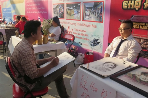 Nghệ sĩ đang thực hiện ký họa cho khách tại hội sách