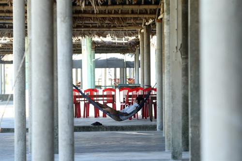 Người dân kinh doanh tại bãi biển Cửa Việt nằm chờ cho qua ngày. Người dân kinh doanh tại bãi biển Cửa Việt nằm chờ cho qua ngày.