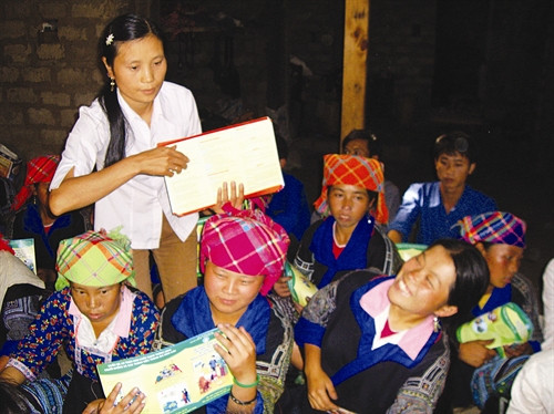 Cán bộ dân số phát tài liệu tuyên truyền về tảo hôn, hôn nhân cận huyết thống cho đồng bào ở huyện Mù Cang Chải