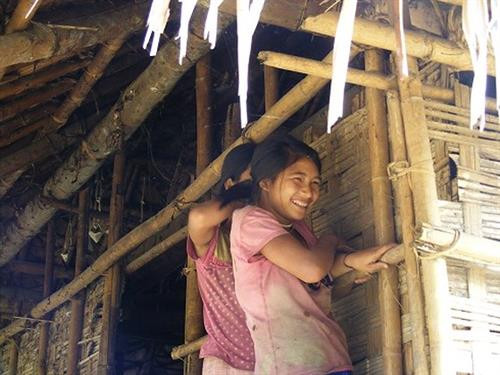 Thiếu nữ Đan Lai e lệ nép vào một góc nhà khi thấy người lạ