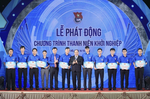 Thủ tướng Nguyễn Xuân Phúc và Bí thư thứ nhất Trung ương Đoàn Lê Quốc Phong trao vốn hỗ trợ cho 10 dự án khởi nghiệp của thanh niên, sinh viên. Ảnh: Phạm Kiên – TTXVN