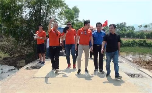 Niềm vui của người dân và đại biểu khi đi trên cây cầu đường vượt lũ vững chãi và chắc chắn. Ảnh: Võ Dung-TTXVN