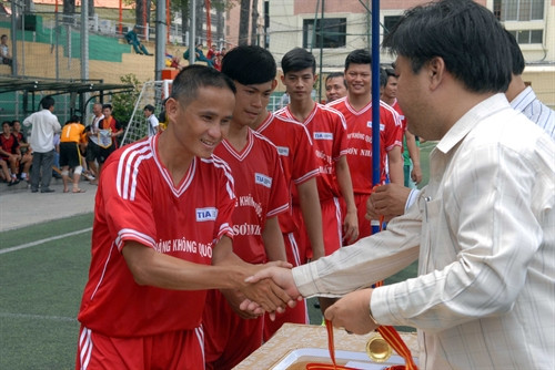 Ông Nguyễn Quốc Tuấn, Phó Giám đốc Cơ quan TTXVN khu vực phía Nam trao huy chương vàng cho các nhà vô địch Giải bóng đá TTXVN mở rộng lần II - Cúp Mắt Bão 2015 - Cảng Hàng không Quốc tế Tân Sơn Nhất