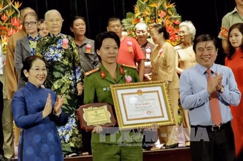 Chủ tịch UBND Thành phố Nguyễn Thành Phong và bà Võ Thị Dung, Phó Bí thư Thành ủy chúc mừng và tôn vinh các gương điển đình tại buổi lễ. Ảnh: Thế Anh - TTXVN
