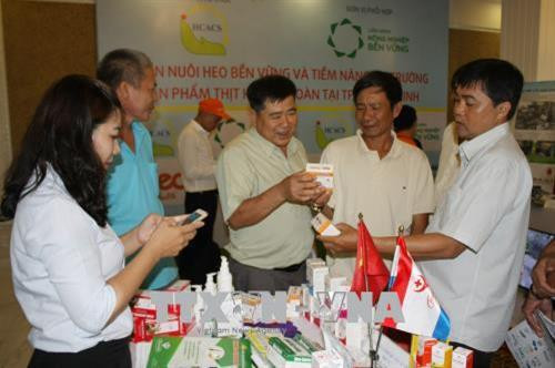 Các chủ trang trại tìm hiểu về sản phẩm thú y được trưng bày tại Hội nghị. Ảnh: Tiến Lực – TTXVN