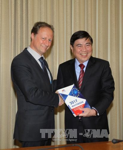 Đại sứ Bruno Angelet tặng sách trắng cho Chủ tịch UBND Thành phố Hồ Chí Minh Nguyễn Thành Phong. Ảnh: Thanh Vũ-TTXVN