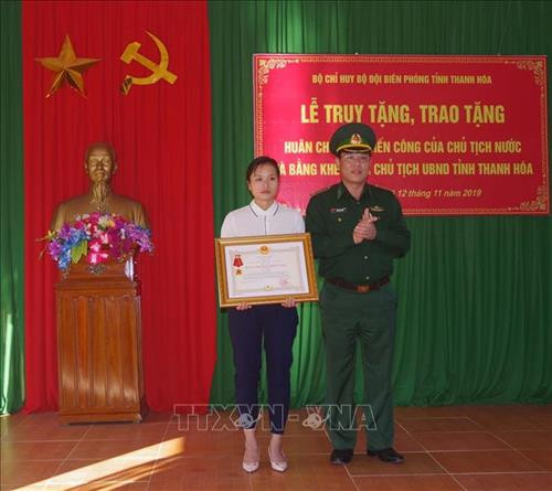 Vợ thiếu tá Vi Văn Nhất đón nhận Huân chương Chiến công hạng Nhất. Ảnh: Trịnh Duy Hưng- TTXVN