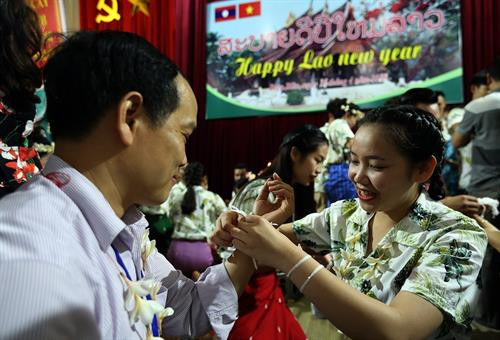 Nghi thức buộc chỉ cổ tay cầu may trong dịp tết cổ truyền Bunpimay. Ảnh: Phan Tuấn Anh - TTXVN Nghi thức buộc chỉ cổ tay cầu may trong dịp tết cổ truyền Bunpimay. Ảnh: Phan Tuấn Anh - TTXVN