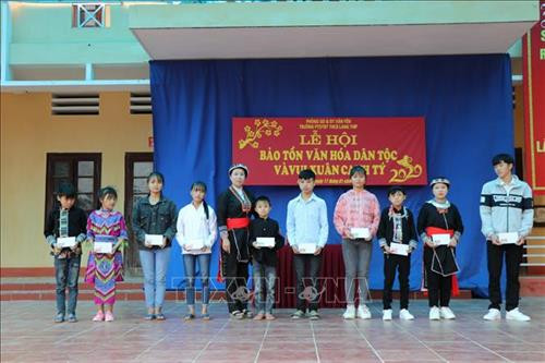 Tặng quà cho các em học sinh. Ảnh: Đức Tưởng - TTXVN Tặng quà cho các em học sinh. Ảnh: Đức Tưởng - TTXVN