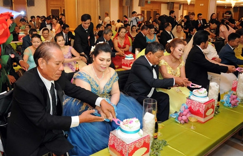 Các đôi uyên ương thực hiện nghi thức cắt bánh cưới tại Lễ cưới tập thể Ảnh: An Hiếu – TTXVN