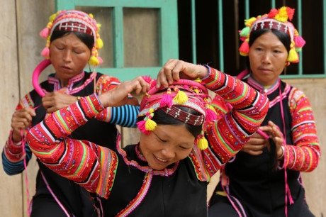 Người La Hủ hay còn gọi là Xá Lá Vàng, Cò Xung, Khù Sung, Khả Quy... hiện có khoảng 10.000 người, sinh sống chủ yếu ở đầu nguồn sông Đà, thuộc huyện Mường Tè, tỉnh Lai Châu. Tuy cuộc sống còn nhiều khó khăn, song đồng bào La Hủ nơi đây vẫn chú trọng gìn giữ bản sắc văn hóa truyền thống, nhất là phụ nữ mặc áo dài tà đen làm nổi bật vóc dáng. Phơ cơ zỡ – tiếng La Hủ có nghĩa là áo dài. Người La Hủ ở Mường Tè thường mặc áo dài tà đen. Các họa tiết, hoa văn... trên mỗi bộ trang phục phụ nữ La Hủ nói lên sự gắn bó giữa cơ thể con người trong sự vận động của cuộc sống với thiên nhiên. Áo dài của người La Hủ ngoài việc mặc ôm sát làm nổi bật đường cong của cơ thể người phụ nữ, còn đẹp ở cách phối màu sắc, cách trang trí và kỳ công của người làm. Mỗi người con gái La Hủ khi đến tuổi thành niên đều tự ý thức may cho mình một chiếc áo dài. Con gái La Hủ thường mặc loại áo cánh tay có nhiều sắc đỏ thể hiện sức sống tươi trẻ và niềm tin yêu cuộc sống. Do hoàn toàn được làm thủ công, nên thời gian để người La Hủ may một chiếc áo dài có khi mất cả tháng mới xong. Duyên dáng thiếu nữ dân tộc La Hủ. Cao nhất trên đầu là vành khăn trang trí với 5 màu sắc. Khăn quấn đầu chủ yếu được làm bằng vải đủ màu và hạt cườm rủ xuống, tạo nét khả ái cho khuôn mặt của người phụ nữ. Để có được bộ trang phục, khăn đội đầu đẹp, đòi hỏi ý tưởng sáng tạo nghệ thuật của người làm. Màu sắc chủ đạo được phối ở cánh tay và điểm xuyết bạc trắng ở thân áo. Làm đẹp cho thân áo còn có sự kết hợp của các hoa văn làm bằng nhôm hình tròn, hình tam giác. Một chiếc áo đẹp còn ở cách trang trí, bài trí những đường diềm tỉ mỉ trên thân áo, tay áo nổi bật lên trên nền vải đen với nhiều màu chỉ đen, đỏ, vàng... May tay áo là công đoạn chiếm nhiều thời gian nhất, có thể tận dụng vải cũ làm lớp lót bên trong, phía ngoài được may ngược. Một ngày với người phụ nữ La Hủ được bắt đầu bằng việc vận trang phục và công đoạn lâu nhất là bện tóc, bọc bằng sợi dây vải màu hồng. Mũ đội đầu Người La Hủ khâu ngực áo rất cẩn thận, đây là công đoạn tách rời những đường viền xếp chồng lên nhau của các loại vải. Việc này không chỉ thể hiện sự khéo léo của những người phụ nữ, mà còn là một trong những nét đẹp trong văn hóa truyền thống của người La Hủ. Vòng quấn đầu được làm từ cây song, mây trên rừng và được điểm tô bằng những chiếc ghim nhôm trang trí. Trang phục truyền thống dân tộc La Hủ đang có nguy cơ mai một, do những thách thức từ điều kiện kinh tế - xã hội.. ...Và việc đồng hóa giữa các dân tộc về phong tục, trang phục. Lớp trẻ dân tộc La Hủ ngày nay thường tự ti khi mặc áo dài dân tộc mình. Người La Hủ hay còn gọi là Xá Lá Vàng, Cò Xung, Khù Sung, Khả Quy... hiện có khoảng 10.000 người, sinh sống chủ yếu ở đầu nguồn sông Đà, thuộc huyện Mường Tè, tỉnh Lai Châu. Tuy cuộc sống còn nhiều khó khăn, song đồng bào La Hủ nơi đây vẫn chú trọng gìn giữ bản sắc văn hóa truyền thống, nhất là phụ nữ mặc áo dài tà đen làm nổi bật vóc dáng. Phơ cơ zỡ – tiếng La Hủ có nghĩa là áo dài. Người La Hủ ở Mường Tè thường mặc áo dài tà đen. Các họa tiết, hoa văn... trên mỗi bộ trang phục phụ nữ La Hủ nói lên sự gắn bó giữa cơ thể con người trong sự vận động của cuộc sống với thiên nhiên. Áo dài của người La Hủ ngoài việc mặc ôm sát làm nổi bật đường cong của cơ thể người phụ nữ, còn đẹp ở cách phối màu sắc, cách trang trí và kỳ công của người làm. Mỗi người con gái La Hủ khi đến tuổi thành niên đều tự ý thức may cho mình một chiếc áo dài. Con gái La Hủ thường mặc loại áo cánh tay có nhiều sắc đỏ thể hiện sức sống tươi trẻ và niềm tin yêu cuộc sống. Do hoàn toàn được làm thủ công, nên thời gian để người La Hủ may một chiếc áo dài có khi mất cả tháng mới xong. Duyên dáng thiếu nữ dân tộc La Hủ. Cao nhất trên đầu là vành khăn trang trí với 5 màu sắc. Khăn quấn đầu chủ yếu được làm bằng vải đủ màu và hạt cườm rủ xuống, tạo nét khả ái cho khuôn mặt của người phụ nữ. Để có được bộ trang phục, khăn đội đầu đẹp, đòi hỏi ý tưởng sáng tạo nghệ thuật của người làm. Màu sắc chủ đạo được phối ở cánh tay và điểm xuyết bạc trắng ở thân áo. Làm đẹp cho thân áo còn có sự kết hợp của các hoa văn làm bằng nhôm hình tròn, hình tam giác. Một chiếc áo đẹp còn ở cách trang trí, bài trí những đường diềm tỉ mỉ trên thân áo, tay áo nổi bật lên trên nền vải đen với nhiều màu chỉ đen, đỏ, vàng... May tay áo là công đoạn chiếm nhiều thời gian nhất, có thể tận dụng vải cũ làm lớp lót bên trong, phía ngoài được may ngược. Một ngày với người phụ nữ La Hủ được bắt đầu bằng việc vận trang phục và công đoạn lâu nhất là bện tóc, bọc bằng sợi dây vải màu hồng. Mũ đội đầu Người La Hủ khâu ngực áo rất cẩn thận, đây là công đoạn tách rời những đường viền xếp chồng lên nhau của các loại vải. Việc này không chỉ thể hiện sự khéo léo của những người phụ nữ, mà còn là một trong những nét đẹp trong văn hóa truyền thống của người La Hủ. Vòng quấn đầu được làm từ cây song, mây trên rừng và được điểm tô bằng những chiếc ghim nhôm trang trí. Trang phục truyền thống dân tộc La Hủ đang có nguy cơ mai một, do những thách thức từ điều kiện kinh tế - xã hội.. ...Và việc đồng hóa giữa các dân tộc về phong tục, trang phục. Lớp trẻ dân tộc La Hủ ngày nay thường tự ti khi mặc áo dài dân tộc mình.