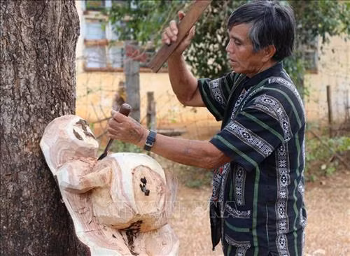 Nghệ nhân ưu tú Ksor Krôh tạc tượng dân gian Tây Nguyên. Ảnh: Hồng Điệp - TTXVN