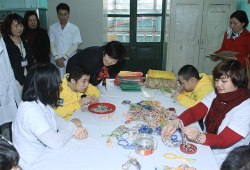 Phu nhân Thủ tướng Nhật Bản Shinzo Abe xem những sản phẩm do người khuyết tật tại Bệnh viện phục hồi chức năng Hà Nội (Làng trẻ em Hoà Bình Thanh Xuân) sản xuất. Ảnh Phạm Kiên- TTXVN
