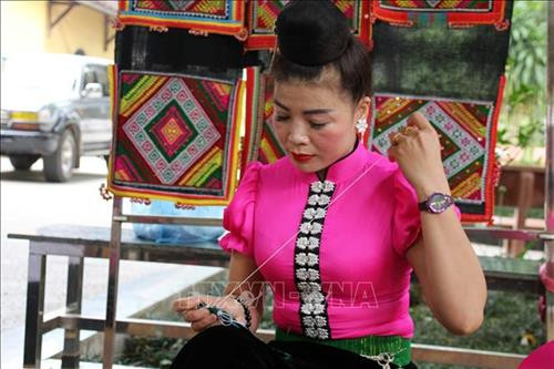 Chương trình tái hiện không gian văn hóa Thái cùng các nghệ nhân làm khăn Piêu, quả Còn. Ảnh: Diệp Anh – TTXVN