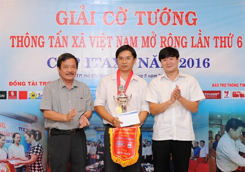 Ông Nguyễn Tiến Lễ (trái), Giám đốc Cơ quan TTXVN khu vực phía Nam và ông Nguyễn Đức Trọng, Giám đốc Công ty TNHH MTV Itaxa trao cúp vô địch và giải nhất cá nhân cho kỳ thủ Phan Thanh Hùng. Ảnh: An Hiếu - TTXVN