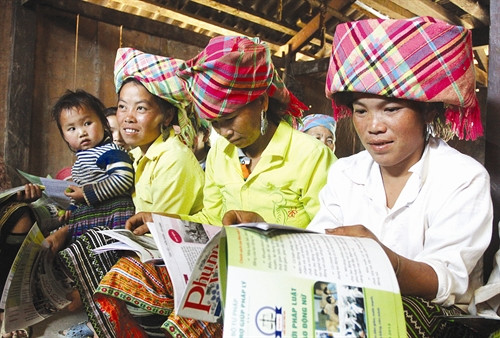 Bà con đọc báo để nâng cao nhận thức về Luật hôn nhân và gia đình