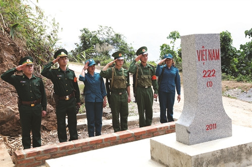 Cán bộ, chiến sĩ Đồn biên phòng 461 phối hợp với dân quân bản Nà Đít, xã Chiềng On huyện Yên Châu thực hiện nghi thức chào cột mốc quốc giới Việt Nam