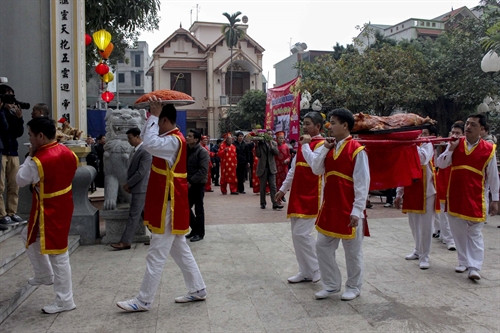 Nghi thức dâng lễ vật cúng tiến lên Thành hoàng làng. Ảnh: Phạm Thảo