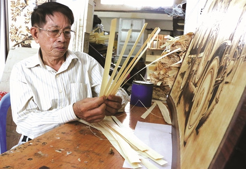 Ông Võ Văn Tạng kiểm tra chất lượng lá thốt nốt trước khi vẽ Ông Võ Văn Tạng kiểm tra chất lượng lá thốt nốt trước khi vẽ