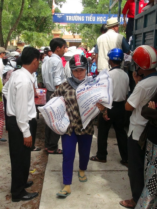 Ngư dân vùng bị ảnh hưởng do sự cố ô nhiễm môi trường cá chết ven biển ở tỉnh Quảng Trị nhận gạo cứu trợ do các tổ chức nhân đạo từ thiện quyên góp, ủng hộ. Ảnh: Trịnh Bang Nhiệm- TTXVN