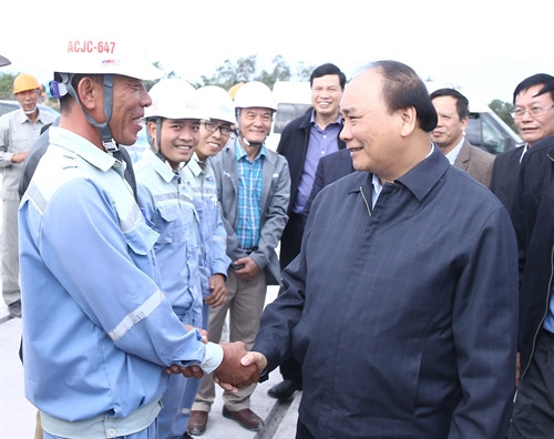 Thủ tướng Nguyễn Xuân Phúc thăm hỏi cán bộ, công nhân đang tham gia xây dựng đường cất cánh, hạ cánh thuộc dự án cảng hàng không Quảng Ninh tại xã Đoàn kết, huyện Vân Đồn, tỉnh Quảng Ninh.Ảnh: Thống Nhất-TTXVN