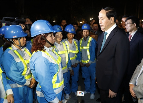 Chủ tịch nước Trần Đại Quang đi thăm, kiểm tra và chúc Tết các công nhân vệ sinh môi trường đang làm nhiệm vụ. Ảnh: Nhan Sáng-TTXVN