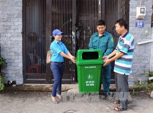 Thanh niên tình nguyện tặng thùng rác cho người dân tại Quận 9 sáng 30/9/2017. Ảnh: An Hiếu – TTXVN Thanh niên tình nguyện tặng thùng rác cho người dân tại Quận 9 sáng 30/9/2017. Ảnh: An Hiếu – TTXVN