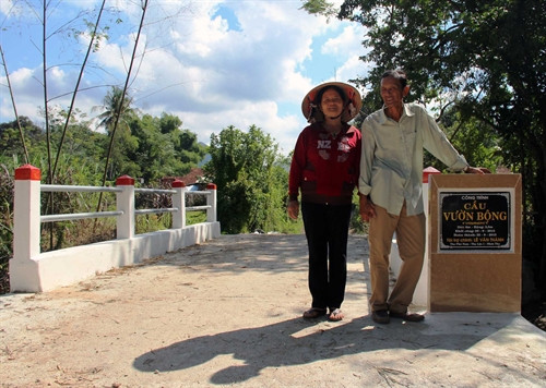 Vợ chồng ông Lê Văn Thành bên cây cầu mơ ước. Ảnh: Quốc Dũng – TTXVN Vợ chồng ông Lê Văn Thành bên cây cầu mơ ước. Ảnh: Quốc Dũng – TTXVN