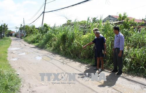Thương binh Nguyễn Văn Sỹ giới thiệu về con đường bên cạnh nhà, do gia đình ông hiến đất để xây dựng, phục vụ nhu cầu đi lại của bà con. Ảnh: Tiến Lực – TTXVN Thương binh Nguyễn Văn Sỹ giới thiệu về con đường bên cạnh nhà, do gia đình ông hiến đất để xây dựng, phục vụ nhu cầu đi lại của bà con. Ảnh: Tiến Lực – TTXVN