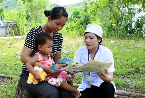 Nhân viên y tế tuyên truyền cho người dân huyện miền núi Vĩnh Thạnh (Bình Định) cách chăm sóc trẻ nhỏ phòng chống suy dinh dưỡng. Ảnh: Dương Ngọc – TTXVN