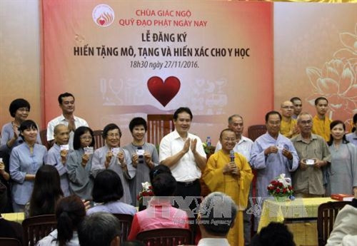 Đại diện Trung tâm Điều phối Quốc gia về ghép bộ phận cơ thể người trao thẻ đăng ký hiến mô, tạng cho các phật tử. Ảnh: Phương Vy- TTXVN.
