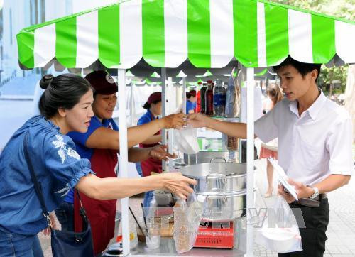 Khách tham quan, mua sắm tại phố ẩm thực hàng rong. Ảnh: An Hiếu - TTXVN