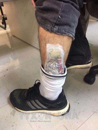Đối tượng giấu đồng hồ trong tất để đi qua “cửa xanh” bị lực lượng Hải quan phát hiện. Ảnh: A.Tuấn - TTXVN