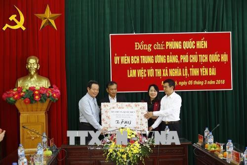 Đồng chí Phùng Quốc Hiển tặng quà cho Đảng bộ, chính quyền thị xã Nghĩa Lộ. Ảnh: Đỗ Tuấn Anh-TTXVN