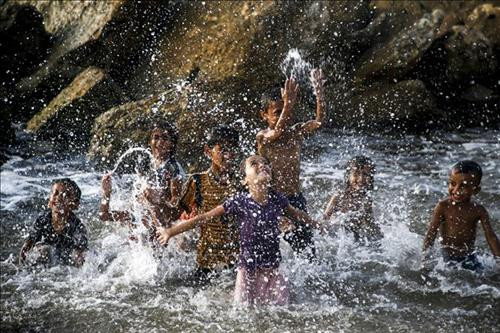 Trẻ em Palestine giải nhiệt tránh nóng tại một bãi biển ở Dải Gaza ngày 5/8/2019. Ảnh: AFP/TTXVN Trẻ em Palestine giải nhiệt tránh nóng tại một bãi biển ở Dải Gaza ngày 5/8/2019. Ảnh: AFP/TTXVN