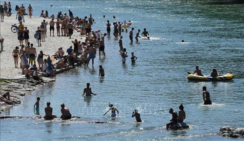Người dân giải nhiệt tránh nóng tại một bãi biển ở Munich, Đức ngày 30/6/2019. Ảnh: AFP/TTXVN Người dân giải nhiệt tránh nóng tại một bãi biển ở Munich, Đức ngày 30/6/2019. Ảnh: AFP/TTXVN