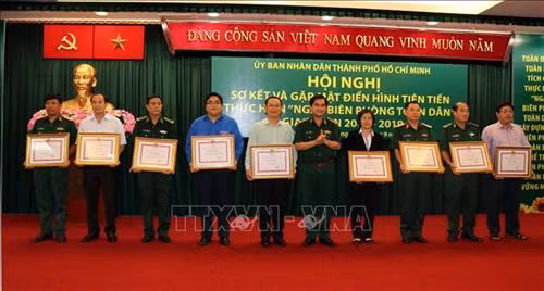 Đại tá Tô Danh Út, Chỉ huy trưởng Bộ đội Biên phòng Thành phố Hồ Chí Minh trao tặng Bằng khen của Chủ tịch UBND Thành phố cho đại diện tập thể đạt thành tích xuất sắc trong thực hiện "Ngày Biên phòng toàn dân" giai đoạn 2009-2019. Ảnh: Xuân Khu-TTXVN