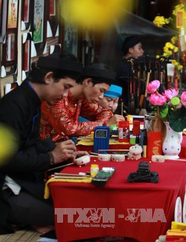 Các ông đồ đã khai bút thư pháp mừng xuân Đinh Dậu 2017. Ảnh: Phương Vy-TTXVN.