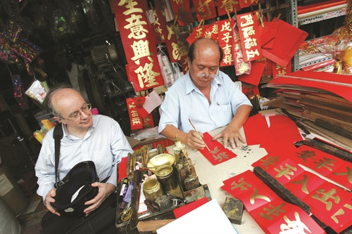 Ông James Winton du khách Mỹ, tò mò xem nhà thư pháp Kim Hy thả từng nét chữ