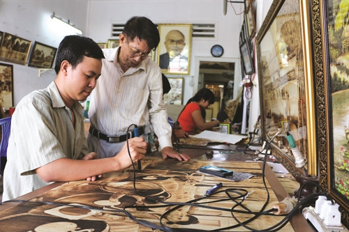 Hướng dẫn các học viên kỹ thuật sử dụng bút lửa trên lá thốt nốt