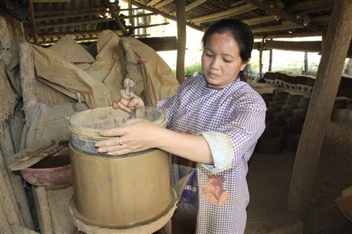 Lát đất mỏng được xếp vào khuôn rồi miết cho đều.