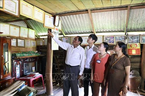 Ông Nay Bim (áo trắng bên trái) với nhiều bằng, khen, giấy khen của các cấp khen tặng. Ảnh: Hồng Điệp - TTXVN Ông Nay Bim (áo trắng bên trái) với nhiều bằng, khen, giấy khen của các cấp khen tặng. Ảnh: Hồng Điệp - TTXVN