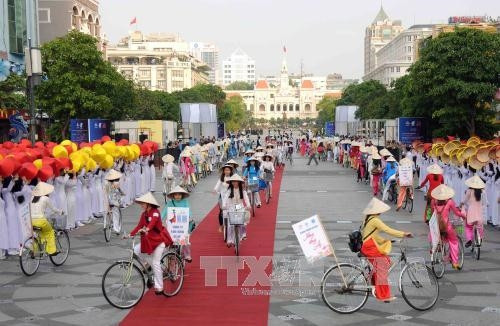 Các sinh viên diễu hành xe đạp “Năng động áo dài” tại chương trình. Ảnh: An Hiếu – TTXVN