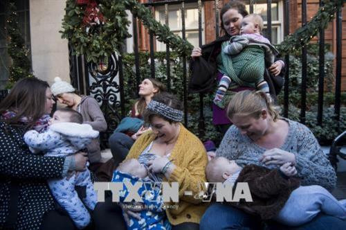 Các bà mẹ cho con bú tại London, Anh. AFP/TTXVN Các bà mẹ cho con bú tại London, Anh. AFP/TTXVN